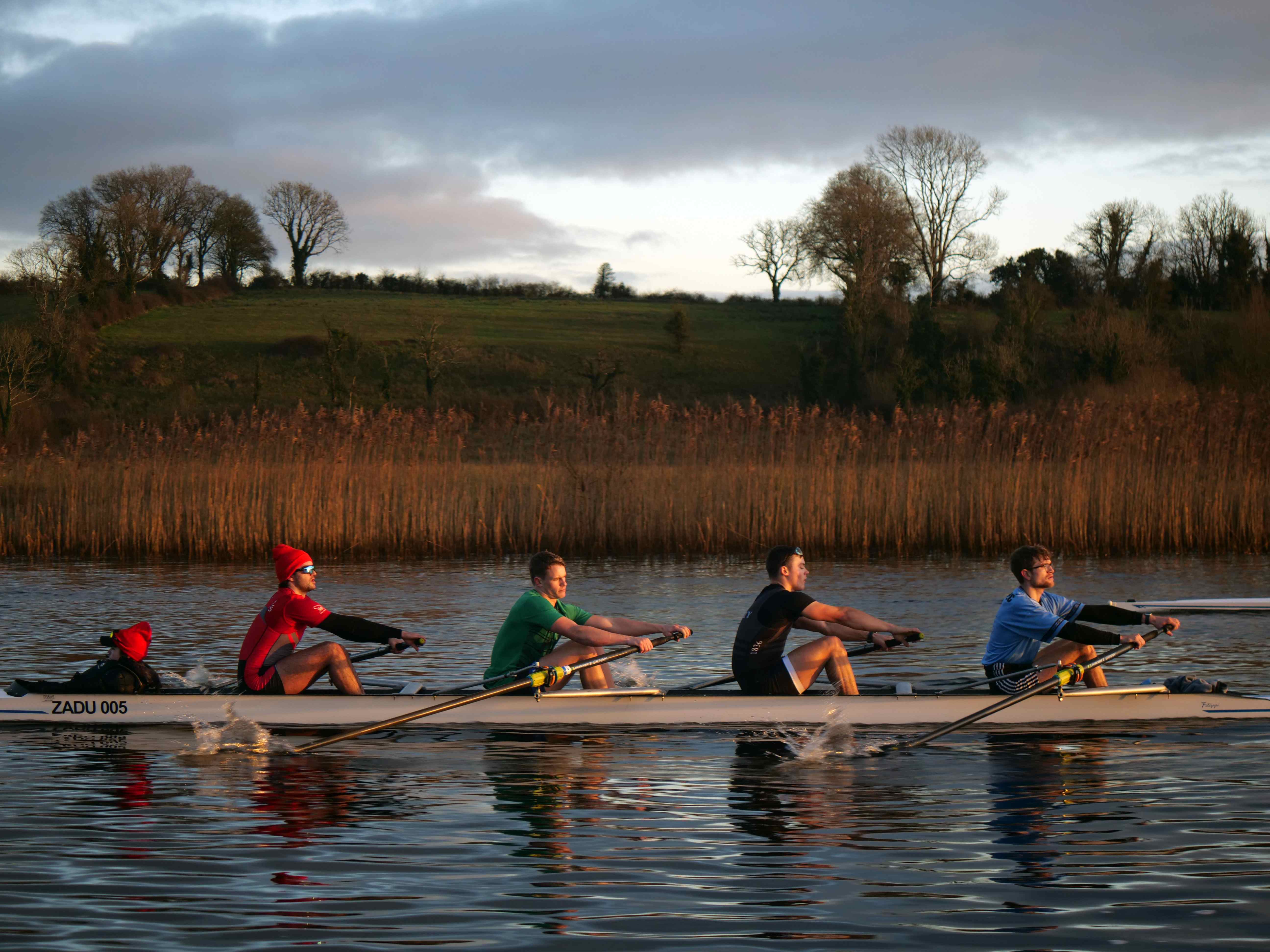 Rowing crew on water at golden hour